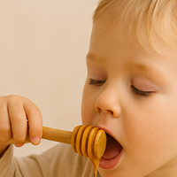 Manuka Honey for kids - a Kid with a spoon of honey